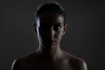 Dramatic portrait of a young woman with shadow and light play