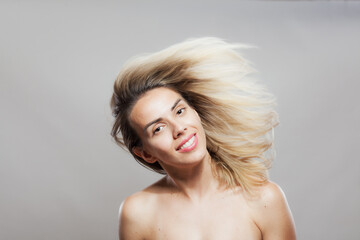 Beautiful girl fashion portrait with windy hair. Looking at camera.