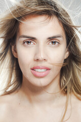 Fototapeta premium Close-up portrait of a young woman with wind-swept hair and natural makeup