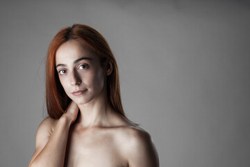 This image captures a serene portrait of a young woman with red hair and an introspective...