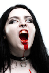 Scary gothic girl with white eyes and bloody mouth screaming.