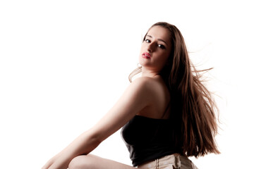 Fototapeta premium Studio poirtrait of a beautiful girl with long hair sitting. Isolated on white background.