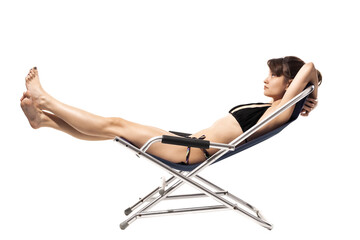 Obraz premium Beautiful young girl in swimsuit relaxing on beach deckchair isolated on white background. Summer concept.