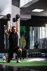 Focused man lifting heavy dumbbells in a modern gym, showcasing strength and determination