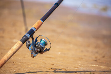Close-up of fishing rod reels. Fishing on the shore of the lake. Spinning rods for sport fishing.