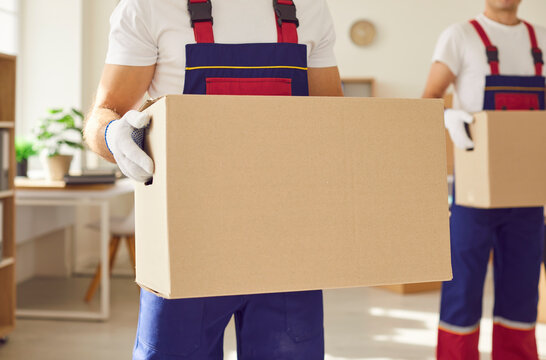 Detailed close up of a hands of man movers handle cardboard boxes, ensuring a secure and efficient delivery service for home or office relocation. Showing precision in the moving process.