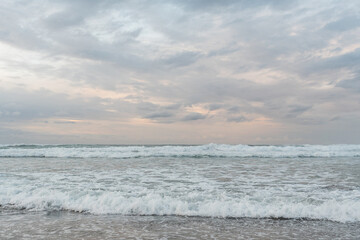 Foam waves on the beach at sunset