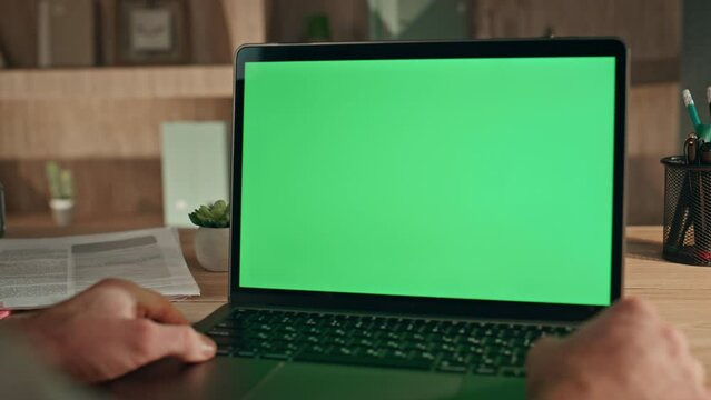 Online student watching mockup laptop at home close up. Man looking green screen