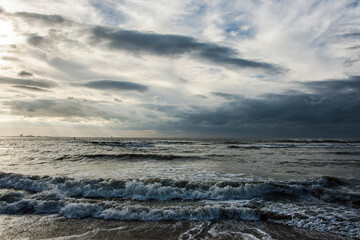 Fototapeta premium dark clouds of a rain shower above the sandy Northsea beach near Cadzand on a stormy day