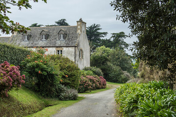 typical house with big chimneys on the countryside of the French region Bretagne with a beautiful...