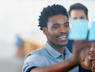 Glass, wall and black man planning with writing on note in office with team strategy or...