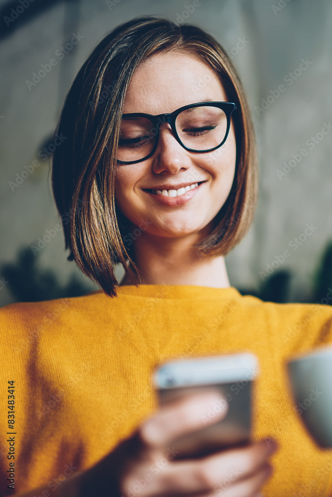 Aufkleber positive female internet user with stylish haircut and eyewear enjoying cappuccino while installing 