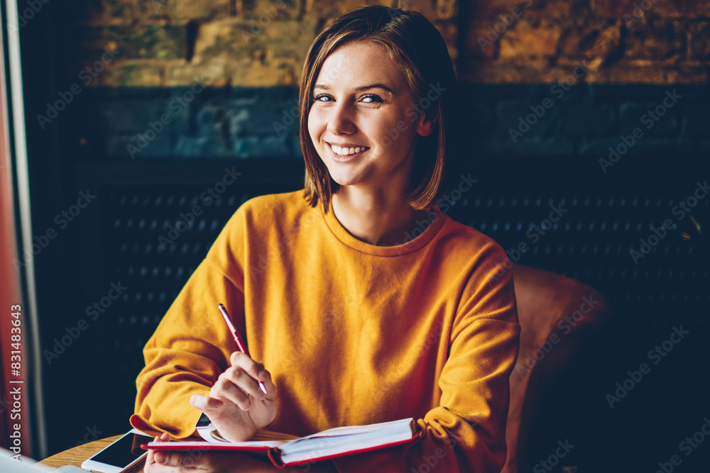 Aufkleber half length portrait of successful skilled student with literature book in hands smiling at camera w