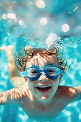 Naklejka premium A young child grinning with joy, wearing swimming goggles, in a sparkling clear blue pool. Summer day