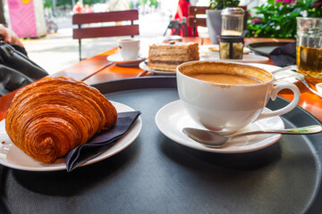Breakfast view a bunch of croissant and a cup of coffee with cafe vibe background.