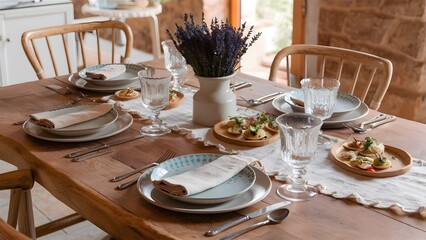 Wooden dining table in rustic style. The table is set in Provence style. Lying cotton napkins, neat and beautiful metal utensils. 