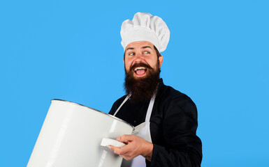 Cooking and culinary. Smiling chef cook in apron with big pot or pan. Happy bearded man in chef hat and uniform with casserole or saucepan. Cookware, dinnerware, kitchenware and kitchen utensils.