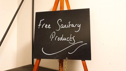 A small blackboard promoting free sanitary products in chalk handwriting  