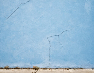 On a very old wall you can see cracks of blue and white background colors. 