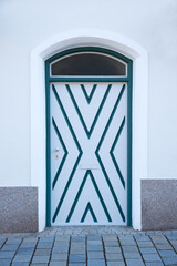 vintage arched door with painted planks in white and dark green.