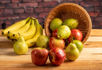 Basket with fruits on rustic wooden surface and dark background, selective focus.