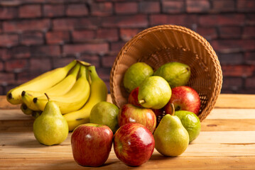 Basket with fruits on rustic wooden surface and dark background, selective focus.