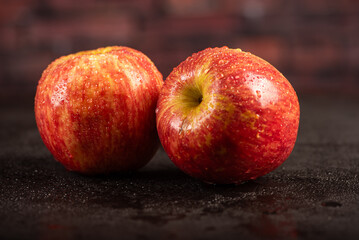 Beautiful apples placed on dark reflective surface, selective focus.