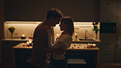 Happy spouses dancing sensually at dark kitchen close up. Couple evening date