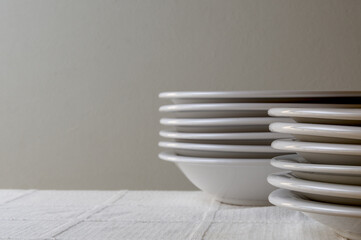 White plates stacked on a table with white tablecloth