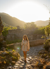Naklejka premium A young tourist girl walking around Kayakoy, Fethiye. It is an abondoned village and it is located in Muğla which is south west of Turkey. She is in vacation. Freedom, travel, tourism concept photo.