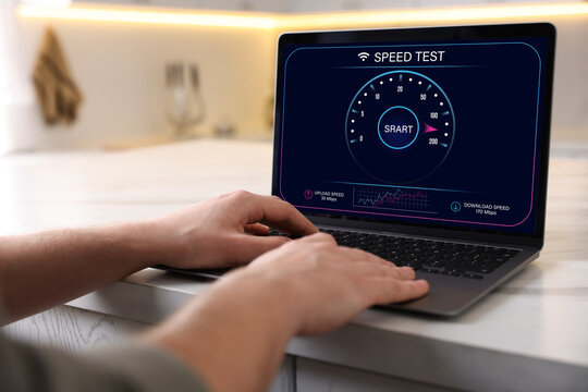 Speed test. Man using laptop at table, closeup - Powered by Adobe