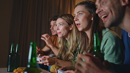 Joyful friends competing video game at home couch close up. Team rejoicing 