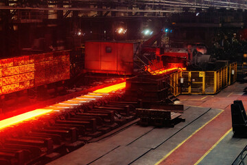 Rolled metal factory. Hot iron slab moving on conveyor of metal rolling mill