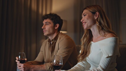 Couple spending first date in cozy evening apartment holding wineglasses closeup