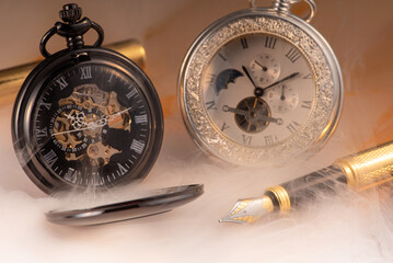 Beautiful pocket watch and vintage fountain pen on rustic wood, selective focus.