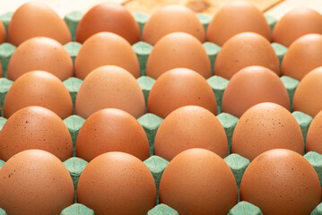 Red eggs placed on a cardboard carton for sale, on rustic wood, selective focus.