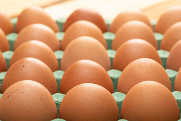 Red eggs placed on a cardboard carton for sale, on rustic wood, selective focus.