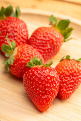 Red strawberries placed on rustic wood, selective focus.