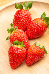 Red strawberries placed on rustic wood, selective focus.