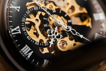 Vintage pocket watch in detail on rustic wood, selective focus.