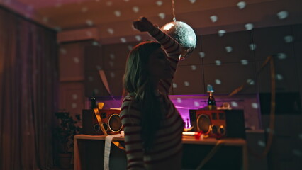 Closed eyes woman dancing in apartment after night party disco ball close up.
