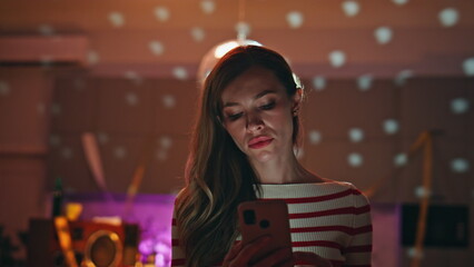 Upset woman texting mobile phone after night party closeup. Serious girl looking