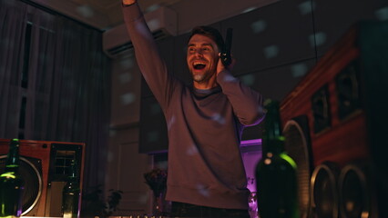 Excited dj waving hand playing music at night disco club close up. Guy mixing 
