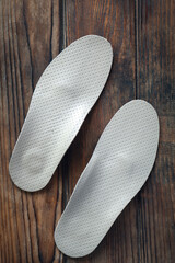 Orthopedic insoles for shoes on a wooden background