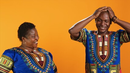 Joyful african american people laughing at something in studio, having fun with jokes and being...