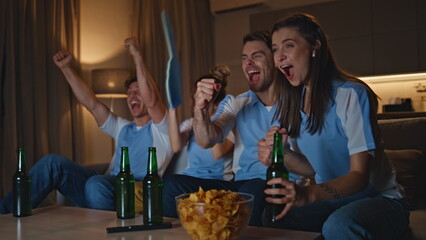 Sport fans watch tv football match on sofa cheering for favorite team close up.