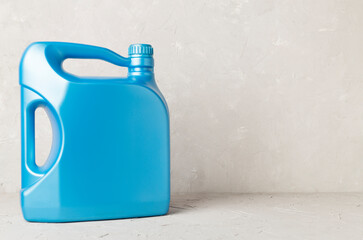 Motor oil in blue canister on concrete background