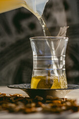 pouring hot steamy tea on traditional turkish glass cup