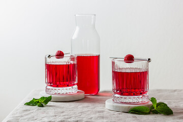 Raspberry cocktail in a glass on a marble stand