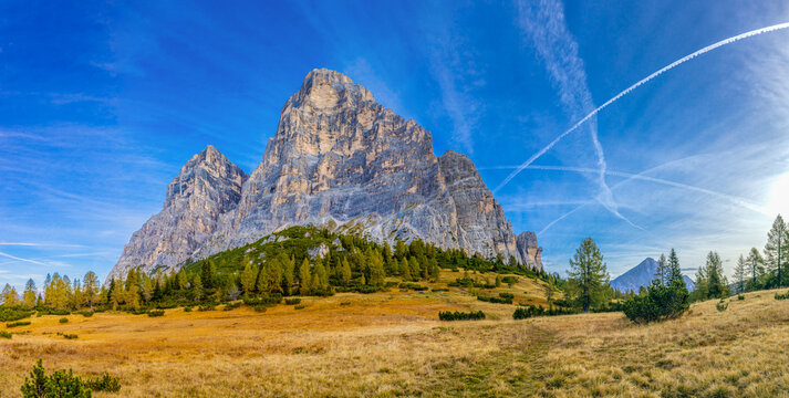 Panorama of the Dolomites mountains on a sunny day, blue sky with soe clouds. Beautiful mountians of Alpi Dolomiti in Italy, South Tirol alpine range in autumn